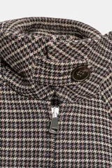 Cazadora estilo bomber acolchada con estampado de pata de gallo, cuello subido con trabilla y botón, manga larga y cierre frontal con cremallera. Presenta bolsillos delanteros y bajo elástico.