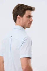 Camisa de manga corta de algodón en color celeste con microdiseño geométrico a cuadros, cuello camisero y bolsillo frontal con logo bordado.