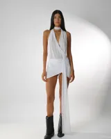 Minivestido blanco de microtul con cuello halter y abertura en la falda.