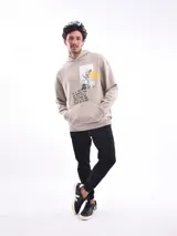 Buzo con capucha (canguro) color verde militar, corte holgado, con bolsillo canguro frontal y estampado gráfico en el pecho.