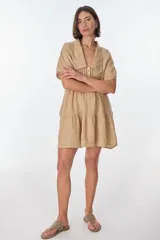 Vestido corto azul de lino italiano con cuello Peter Pan con detalle de encaje, escote en V con botones frontales y corte imperio con volados en la falda. Mangas cortas tipo mariposa.