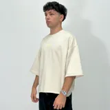 Remera color crema de corte boxy, manga 3/4 y estampado con el número 1999 en el centro del pecho.