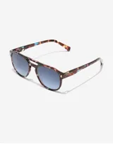Lentes de sol Hawkers modelo Diver, con armazón de acetato en estampado carey con detalles en azul y cristales degradados en tono azulado. Diseño estilo aviador con doble puente.