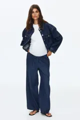 Pantalón tipo jean de corte holgado en denim suave, con diseño de piernas globo, cintura elástica con cordón de ajuste y bajos fruncidos con cordones ajustables.