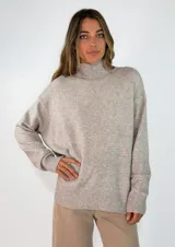 Sweater de punto con cuello alto, manga larga y diseño holgado. Presenta puños y ruedo acanalados.