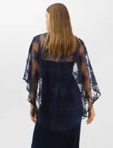 Vestido largo de corte sirena en color azul marino, confeccionado en tejido de punto con caída fluida. Presenta una capa integrada de tul fino sobre los hombros y espalda, decorada con bordados florales a tono y lentejuelas brillantes. Posee escote redondo y cierre invisible en la espalda.