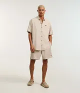 Bermuda masculina de corte recto y color beige, con cintura elástica, cordón ajustable y bolsillos laterales. Pertenece a la marca Ripping.