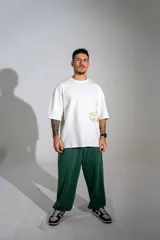 Pantalón de jogging verde oscuro con corte holgado, cintura elástica con cordón de ajuste y bolsillos laterales.