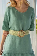 Cinturón ancho de polipropileno color beige con detalles en verde, con hebilla circular símil carey.