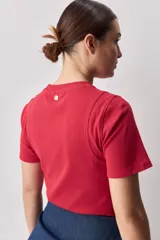 Remera blanca de manga corta y cuello redondo, con calce ajustado al cuerpo y diseño liso y minimalista.