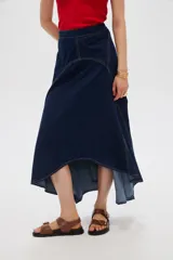 Falda larga de denim azul oscuro con costuras en contraste y diseño asimétrico de corte evasé.