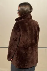 Campera reversible de cuero ovino, color azul marino, con interior de piel sintética blanca. Presenta cuello alto, cierre frontal y bolsillos frontales aplicados.