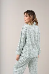 Pijama de dos piezas celeste con estampado floral, compuesto por camisa de manga larga abotonada y pantalón largo.