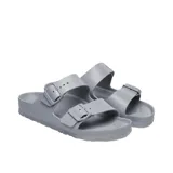 Sandalias tipo zueco Birkenstock modelo Arizona, fabricadas en EVA de color gris claro. Presentan dos tiras ajustables con hebillas metálicas.