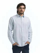 Camisa de manga larga color celeste claro, confeccionada en mezcla de lino y viscosa, con cuello clásico y botones frontales. Presenta un botón y presilla en la manga para sujetarla remangada.