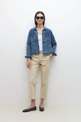Pantalón color beige de corte recto, con cinturón de cuero sintético trenzado.