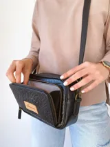 Bandolera negra de cuero con forro de tela, bolsillo interior y exterior.