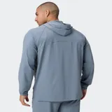 Campera deportiva Fabletics The One de color negro, con capucha, cierre frontal completo y bolsillos laterales. Confeccionada en tejido ligero y de secado rápido con mangas raglán.
