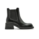 Bota tipo chelsea de cuero negro con elástico lateral decorado con tachas metálicas plateadas, punta cuadrada y taco bajo cuadrado con textura.