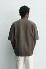 Camiseta boxy fit color verde militar con efecto lavado, confeccionada en tejido compacto de algodón con cuello redondo y manga corta.