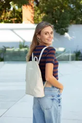 Mochila de cuero color natural con textura, cierre superior con doble cremallera, asa de mano y correas ajustables para los hombros.