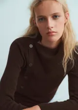 Sweater de punto fino color marrón chocolate, con cuello asimétrico, cierre lateral con botones y manga larga.