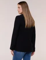 Blazer de silueta semientallada confeccionado en sastrería liviana de corte fluido, color negro, con solapa muesca clásica, cierre frontal de un solo botón, bolsillos frontales con solapa y mangas largas con puños de detalle abotonado.