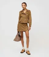 Short pollera de diseño corto confeccionado en gamuza sintética (suede) de tacto suave. Presenta cintura fija, cierre lateral y una pequeña abertura en el ruedo.