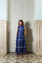 Vestido largo azul marino de popelina 100% algodón, sin mangas, con cuello alto, bolsillos laterales y estampa de cuadros. Presenta una silueta en línea A y caída relajada.