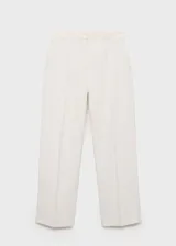 Pantalón de vestir color crema, de corte recto, con cierre de botón y cremallera, tiro medio y bolsillos laterales. Ideal para fiestas y ceremonias.