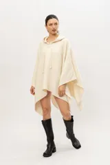 Poncho tejido en telar en 100% lana merino color crudo, con capucha y cordones de ajuste.