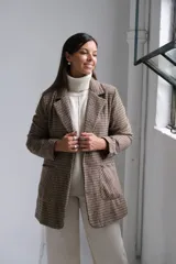 Blazer de corte recto con estampado de cuadros tipo príncipe de gales en tonos marrones y beige. Presenta solapas clásicas, bolsillos frontales aplicados y mangas largas.