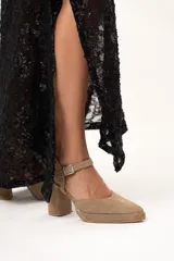 Sandalias de tacón color visón con puntera triangular y tira con hebilla al tobillo.