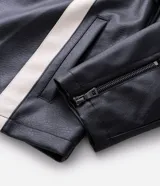 Campera biker de cuero sintético negro con detalles en blanco, cuello mao con broche, cierre frontal y parches bordados en el pecho. Presenta diseño acolchado en los hombros y mangas largas.