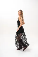 Vestido largo negro de encaje con cuello halter y espalda descubierta, con forro corto y falda translúcida.