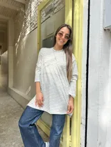 Remerón de manga larga con diseño a rayas horizontales en color beige y blanco, de corte oversize y cuello redondo.