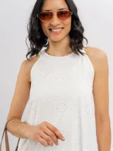 Vestido corto blanco de broderie, sin mangas y con escote halter de corte evasé.