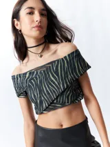 Top negro con estampado de cebra en verde, de corte cropped, con escote off-shoulder y mangas cortas.
