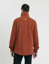 Sobrecamisa de micropolar color terracota, con cuello camisero, cierre frontal con botones a presión y dos bolsillos frontales con solapa y botón.