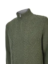 Sweater de punto color verde oliva, con cuello alto y cierre frontal parcial. Presenta un diseño de tejido con textura de rombos y trenzas verticales, con puños y ruedo acanalados.