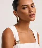 Blusa peplum sin mangas confeccionada en viscosa blanca con escote recto, breteles anchos y traspase delantero. Presenta tejido texturizado, adorno en los breteles y forro.