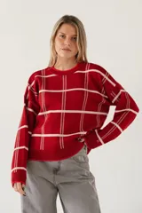 Sweater de punto color rojo con diseño de cuadrícula en color blanco, de corte holgado, cuello redondo y mangas largas con puños acanalados.