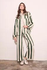 Sobrecamisa oversize con estampado a rayas verticales verdes y blancas, con cuello clásico, cierre frontal con botones y bolsillos de parche en el pecho.