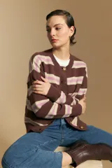Cardigan de punto con diseño de rayas horizontales en tonos marrón, rosa y beige. Presenta cuello redondo, cierre frontal con botones y mangas largas con puños acanalados.
