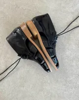 Sandalias acordonadas de cuero vacuno color negro, con plataforma de madera clara.