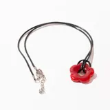 Collar con colgante de flor roja y cordón negro con cadena de alargue plateada.
