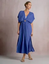 Vestido midi túnica color azul de la marca Elan, de corte holgado con escote en V profundo y mangas mariposa. Cuenta con una argolla central forrada que une el fruncido del busto y genera sutiles aberturas cut-out en la cintura. Presenta cintura elastizada y falda fluida con tajo lateral.