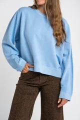 Buzo lila oversize confeccionado en 100% algodón, con cuello redondo, mangas largas y puños y dobladillo acanalados. Presenta un pequeño detalle bordado en el bajo.
