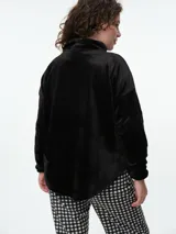 Buzo de dormir de tela fleece con estampado animal print en tonos grises y blancos. Presenta cuello alto con cierre de botones a presión y mangas largas.