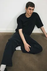 Jeans de cinco bolsillos en denim de algodón rígido, color negro lavado. Modelo de cintura estándar con cierre y corte relajado de cadera a bajo con pierna recta amplia.